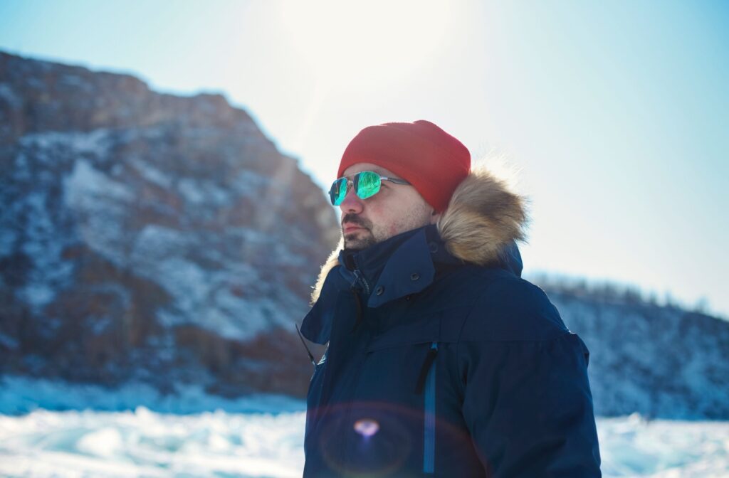A person on a winter vacation wears a pair of polarized sunglasses to prevent light rays reflected off the snow damaging their eyes.